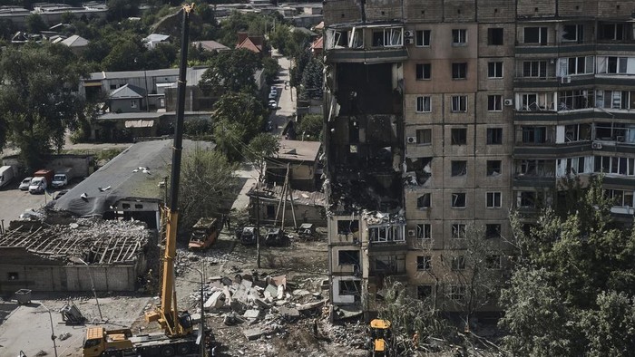 Emergency services work at a scene after a missile hit an apartment building in Kryvyi Rih, Ukraine, Monday, July 31, 2023. (AP Photo/Libkos)