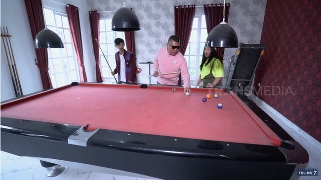 Ada sebuah ruangan yang khusus didedikasikan untuk bermain biliar. Warna mejanya matching dengan tirai berwarna merah. (Foto: YouTube/Trans7 Official)