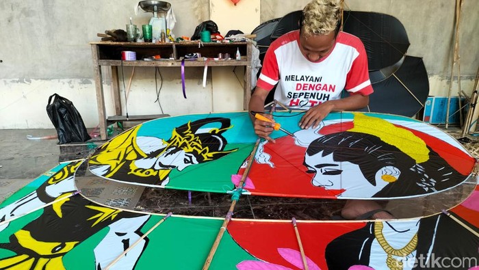 Sholichin membuat laying-layang jenis pegon di rumahnya, Selasa (1/8/2023).
