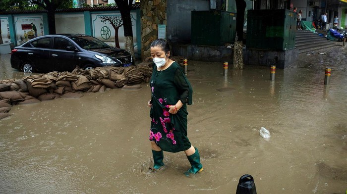 Banjir menyisakan material lumpur di sejumlah jalan di Beijing, China, Selasa (1/8/2023). Warga pun mulai membersihkan lumpur yang menyelimuti jalanan tersebut.