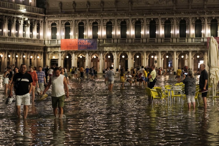 Banjir Lagi, Kota Indah Venesia Terancam Masuk Daftar Hitam UNESCO Tourists walk through flooded St Marks Square after unusually high water levels in Venice, Italy, August 1, 2023. REUTERS/Manuel Silvestri
