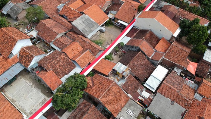 Foto udara bendera merah putih dibentangkan di atas jalan Desa Pekauman Kulon, Kabupaten Tegal, Jawa Tengah, Rabu (2/8/2023). Bendera sepanjang 150 meter dan lebar dua meter yang dijahit selama lima hari tersebut dipasang dalam rangka menyambut HUT ke-78 Kemerdekaan RI. ANTARA FOTO/Oky Lukmansyah/aww.