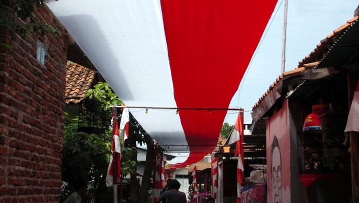 Foto udara bendera merah putih dibentangkan di atas jalan Desa Pekauman Kulon, Kabupaten Tegal, Jawa Tengah, Rabu (2/8/2023). Bendera sepanjang 150 meter dan lebar dua meter yang dijahit selama lima hari tersebut dipasang dalam rangka menyambut HUT ke-78 Kemerdekaan RI. ANTARA FOTO/Oky Lukmansyah/aww.