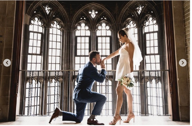 Dalam foto yang diunggah ke Instagram terlihat mantan istri Marcelino Lefrandt tampil simpel minimalis di hari pernikahannya. Dewi mengenakan gaun pengantin berpotongan mini berwarna putih, kalung mutiara dan veil putih yang menghiasi rambut cepolnya. Foto: Dok. @prito.reza via @thebridestory