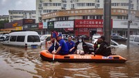 Perahu karet juga hilir mudik untuk mengevakuasi warga yang terjebak banjir. Reuters/Thomas Peter.