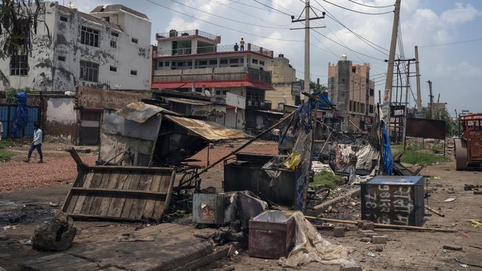Horor Bentrokan Kelompok Agama di India, 5 Orang Tewas Broken glass and debris are strewn on a street as policemen patrol after communal clashes in Nuh in Haryana state, India, Tuesday, Aug., 1, 2023. Deadly clashes between Hindus and Muslims began in the area Monday afternoon during a religious procession by a Hindu nationalist group forcing Indian authorities to impose a curfew and suspend Internet services. (AP Photo/Altaf Qadri)