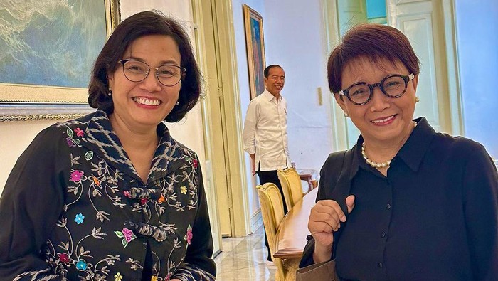 Menkeu Sri Mulyani dan MenluRetno Marsudi curi-curi momen foto bersama saat reuni di Istana Merdeka, Jakarta Pusat. Presiden Jokowi yang menyaksikan momen tersebut pun tersenyum.