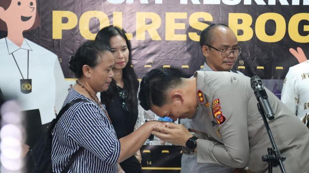 Kapolres Bogor AKBP Rio Wahyu Anggoro mencium tangan ibunda Bripda IDF alias Bripda ID, polisi yang meninggal usai tertembak rekannya Bripda IM. (dok Ist)