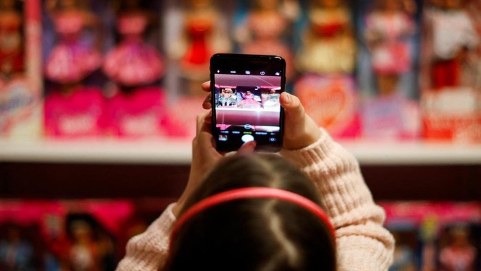 Barbie dolls are displayed as people walk behind in The Barbie Collector exhibition at The Wellington Museum, in Wellington, New Zealand July 29, 2023. REUTERS/Amanda Perobelli
