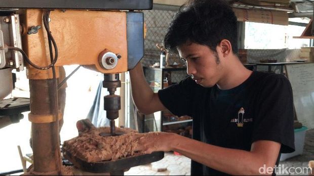 Pengrajin di Komunitas BangKayu tengah membuat asbak dari limbah kayu.