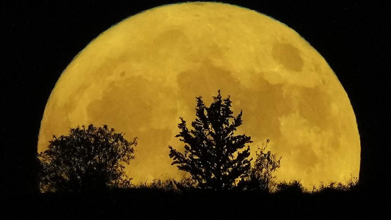 The supermoon rises behind a hill at Pera Chorio Nisou, outskirts of Nicosia, Cyprus, Tuesday, Aug. 1, 2023. The moon appears slightly brighter and bigger than normal because it is closer than usual, just 357,530 kilometers (222,159 miles) away, thus the supermoon label. (AP Photo/Petros Karadjias)