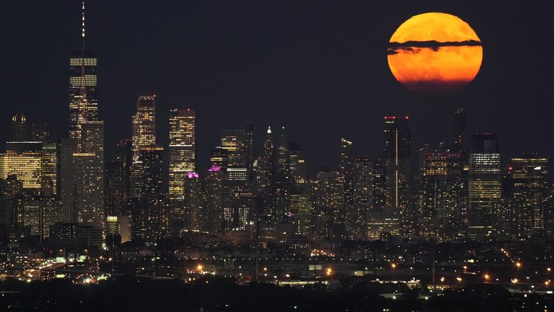 The moon rises through clouds over the skyline of lower Manhattan as seen from West Orange, N.J., Tuesday, Aug. 1, 2023. The first of two supermoons in August graced the skies on Tuesday. A supermoon is broadly defined as a full moon that is closer to the Earth than normal. That makes it appear slightly brighter and bigger in the sky. (AP Photo/Seth Wenig)