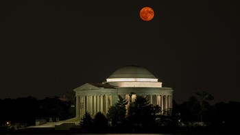 Supermoon terbit di atas Thomas Jefferson Memorial di Tidal Basin di Washington, Amerika Serikat, Selasa (1/8/2023). (AP Photo/Carolyn Kaster)