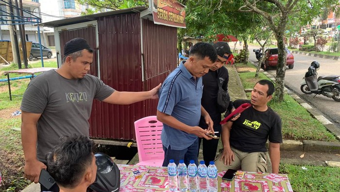 Pelaku penipuan (tengah baju biru) di Merangin, Jambi ditangkap saat santai minum es dogan di warung.