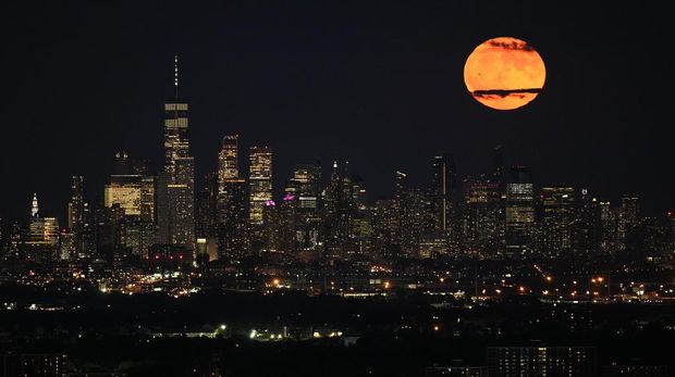 The moon rises through clouds over the skyline of lower Manhattan as seen from West Orange, N.J., Tuesday, Aug. 1, 2023. The first of two supermoons in August graced the skies on Tuesday. A supermoon is broadly defined as a full moon that is closer to the Earth than normal. That makes it appear slightly brighter and bigger in the sky. (AP Photo/Seth Wenig)