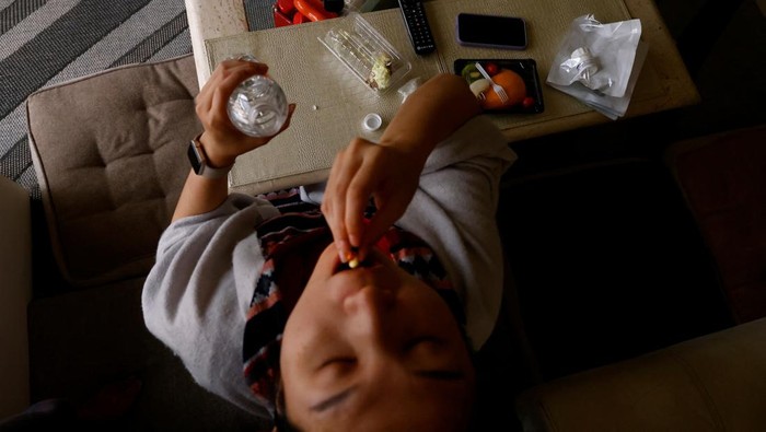 Vivian Tung, 33, who is one of a rising number of women opting to freeze their eggs, takes painkillers after her egg retrieval surgery, at home in New Taipei City, Taiwan, June 19, 2023. Even though under current laws women cannot use their frozen eggs unless they are in a heterosexual marriage, demand for egg freezing in Taiwan has surged and more than a dozen centres offering egg freezing services opened last year. 