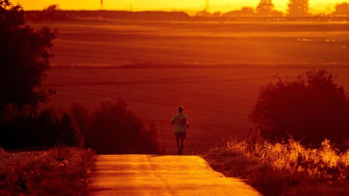 Warga Eropa Berburu Alat Pendingin untuk Hadapi Cuaca Panas Ekstrem FILE - A man uses cool morning hours for a run on a small road in the outskirts of Frankfurt, Germany, Monday, July 18, 2022. Rising global temperatures are elevating air conditioning from a luxury to a necessity in many parts of Europe, which long has had a conflictual relationship with energy-sucking cooling systems deemed by many a U.S. indulgence. (AP Photo/Michael Probst, file )