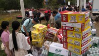 Relawan menyiapkan pasokan makanan dan air untuk warga terdampak banjir.