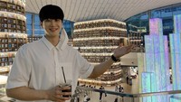 Datang ke perpustakaan ikonik di Korea Selatan,  Ahn Bo Hyun tak ketinggalan berpose. Pemain drama Itaewon Class ini menenteng segelas es kopi.