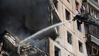 Para petugas pemadam kebakaran berusaha memadamkan api yang melalap beberapa lantai gedung apartemen tersebut. Press service of the State Emergency Service of Ukraine/Handout via Reuters.  