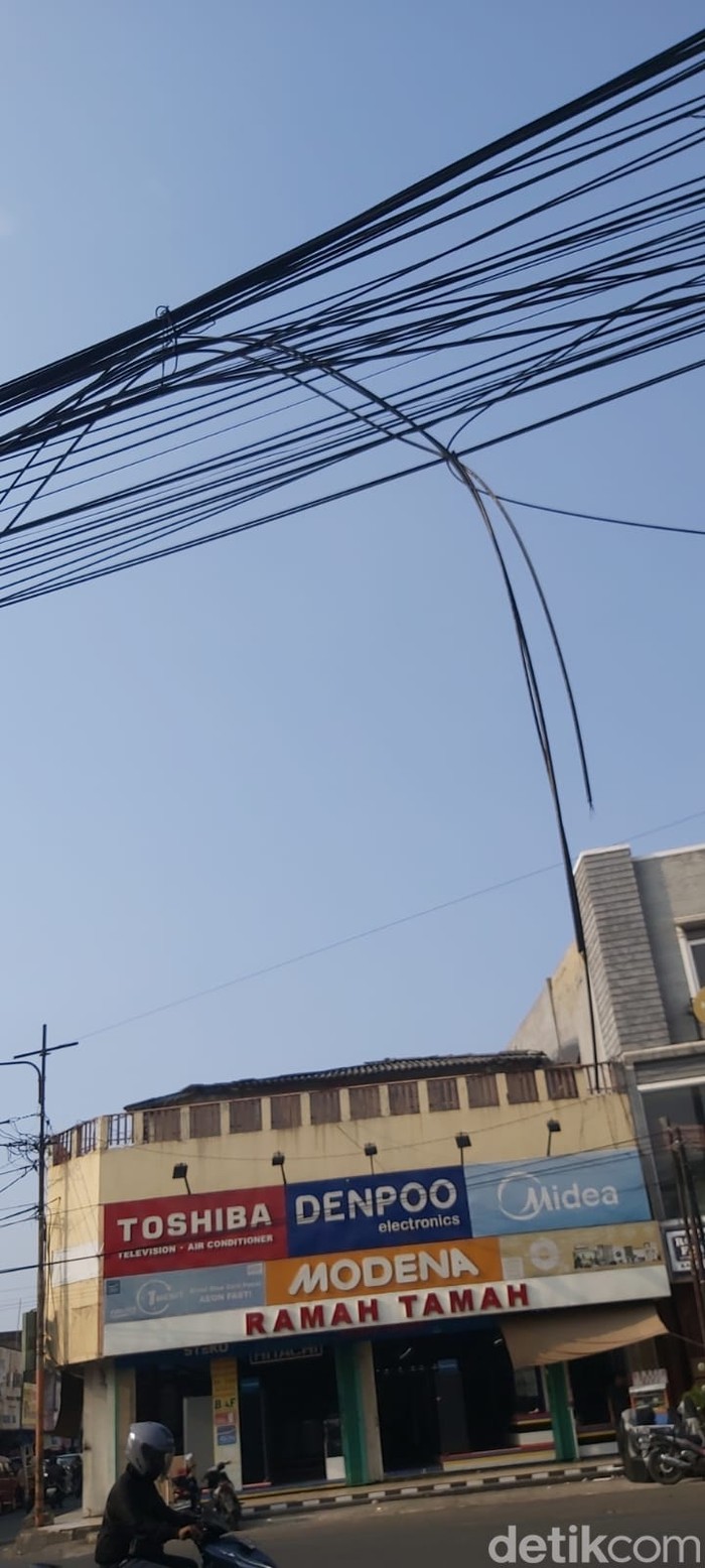 Kabel menjuntai di jalanan dekat Bekasi Junction, Kota Bekasi, 3 Agustus 2023. (Dwi Andayani/detikcom)