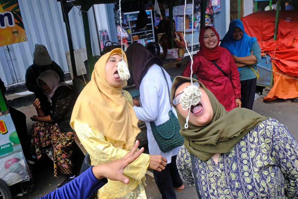 Sejumlah pedagang berlomba adu cepat makan kerupuk di halaman pasar Kliwon Temanggung, Jawa Tengah, Kamis  (3/8/2023). Lomba adu cepat makan kerupuk tersebut untuk menyemarakkan HUT ke-78 Kemerdekaan Republik Indonesia sekaligus untuk menghibur pengunjung pasar . ANTARA FOTO/Anis Efizudin/hp.