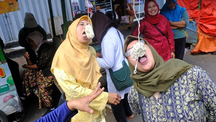 Sejumlah pedagang berlomba adu cepat makan kerupuk di halaman pasar Kliwon Temanggung, Jawa Tengah, Kamis  (3/8/2023). Lomba adu cepat makan kerupuk tersebut untuk menyemarakkan HUT ke-78 Kemerdekaan Republik Indonesia sekaligus untuk menghibur pengunjung pasar . ANTARA FOTO/Anis Efizudin/hp.