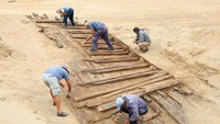 Para arkeolog menggali lambung kapal kayu Romawi kuno yang ditemukan di Viminacium, dekat Kostolac, Serbia, 2 Agustus 2023.
