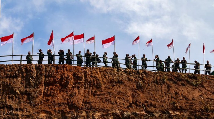 Prajurit TNI berdiri dibawah bendera saat pengibaran bendera Merah Putih simbolis di puncak Gunung Salak, Aceh Utara, Aceh, Rabu (93/8/2023). TNI Kodim 0103 Aceh Utara meprakarsai pemasangan 2000 bendera Merah Putih di kawasan puncak Gunung Salak untuk menyambut perayaan HUT ke-78 Republik Indonesia. ANTARA FOTO/Rahmad/hp.