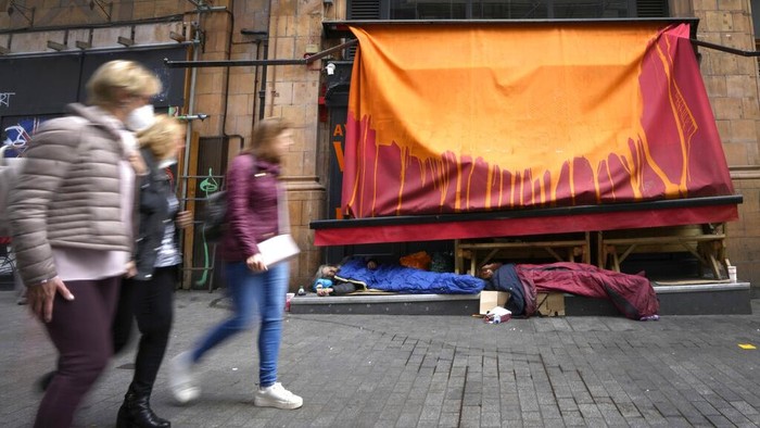Pedestrians pass homeless people sleeping in front of a closed retail unit near Oxford Street in London, Wednesday, April 13, 2022. British consumer prices rose at their fastest pace in 30 years last month, fueled by soaring prices for household energy and motor fuels. The Office of National Statistics reported on Wednesday that inflation accelerated to 7% in the 12 months through March. (AP Photo/Kirsty Wigglesworth)