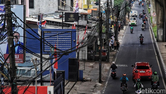 Potret Kabel Semrawut di Ciledug Raya Jaksel Warga melintas di bawah kabel utilitas yang semrawut di Jalan Ciledug Raya, Cipulir, Jakarta Selatan, Kamis (3/8/2023). Terlihat sejumlah kabel lepas dari ikatan, beberapa menjuntai hingga dapat membahayakan pengendara atau warga yang melintas.