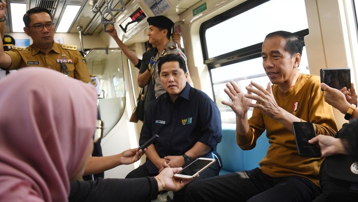 Presiden Joko Widodo (kanan) didampingi Menteri BUMN Erick Thohir (tengah), dan Gubernur Jawa Barat Ridwan Kamil (kiri) menaiki LRT Jabodebek di Jakarta, Kamis (3/8/2023). Presiden menggunakan moda transportasi LRT dengan rute Stasiun Harjamukti hingga Stasiun Dukuh Atas.