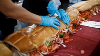 Seorang pria memotong sandwich di di Mexico City, Meksiko, Rabu (2/8/2023).