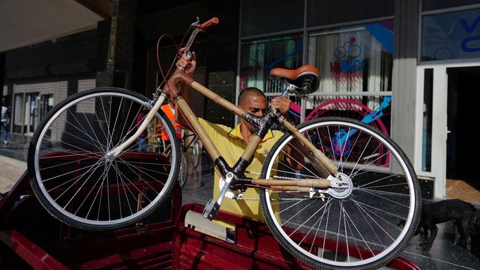 An employee of Velo Cuba unloads from a tricycle an eco-friendly bamboo bicycles in Havana, Cuba, July 21, 2023. REUTERS/Alexandre Meneghini