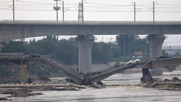 A worker cleans up debris after remnants of Typhoon Doksuri brought rains and floods, at a residential compound in Mentougou district, Beijing, China August 4, 2023. REUTERS/Tingshu Wang