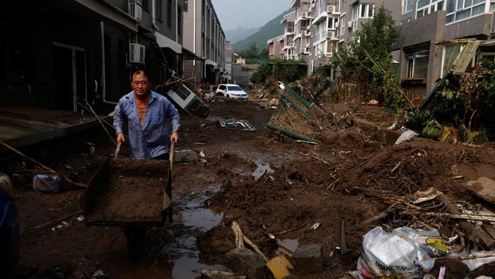 Dampak Topan Doksuri di Beijing, Sampah Numpuk-Jembatan Roboh A worker cleans up debris after remnants of Typhoon Doksuri brought rains and floods, at a residential compound in Mentougou district, Beijing, China August 4, 2023. REUTERS/Tingshu Wang