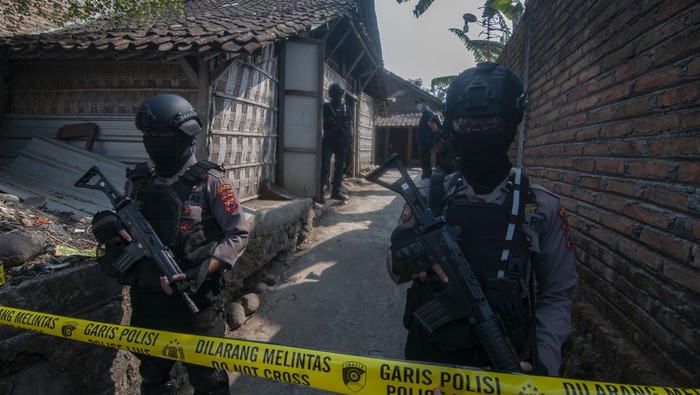 Anggota Polri lengkap dengan senjata menjaga sekitar rumah terduga teroris saat olah tempat kejadian perkara (TKP) di Trayu, Banyudono, Boyolali, Jawa Tengah, Jumat (4/7/2023). Densus 88 Antiteror Polri menangkap dua orang terduga teroris di wilayah Boyolali, yang diduga terafiliasi dengan pelaku bom bunuh diri di Polsek Astana Anyar, Polrestabes Bandung, Jawa Barat. ANTARA FOTO/Aloysius Jarot Nugroho/foc.