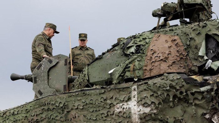 Russian Defence Minister Sergei Shoigu inspects a Swedish CV-90 infantry fighting vehicle, that was abandoned by Ukrainian soldiers after being hit by a hand-held anti-tank grenade, at the frontline headquarters of the 