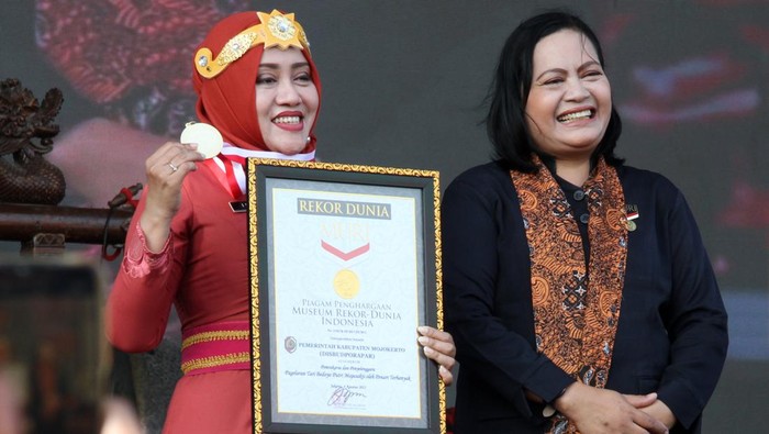 Bupati Mojokerto Ikfina Fahmawati (kiri) menerima piagam Museum Rekor Dunia Indonesia (MURI) dari perwakilan MURI Sri Wijayati (kanan) usai pemecahan rekor Tari Bedoyo Putri Mojosakti di Lapangan Kawiryan, Desa Pacing, Kecamatan Bangsal, Kabupaten Mojokerto, Jawa Timur, Jumat (4/8/2023). Tarian Bedoyo Putri Mojosakti yang digelar pada Majapahit Festival (Majafest) 2023 memecahkan rekor MURI dengan peserta sebanyak 506 orang. ANTARA FOTO/Syaiful Arif/rwa.
