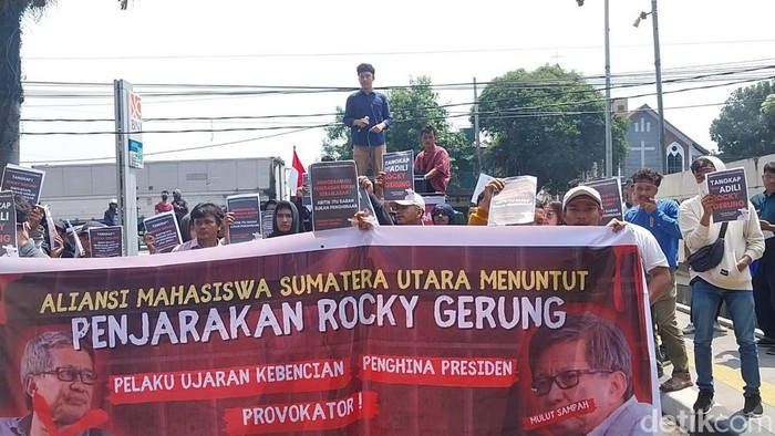 Sejumlah massa menggelar demo di Polda Sumut meminta agar Rocky Gerung ditangkap