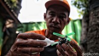 Dengan teliti, Timan menyambungkan bagian-bagian korek api yang telah dipotong-potong sehingga menjadi helikopter.  