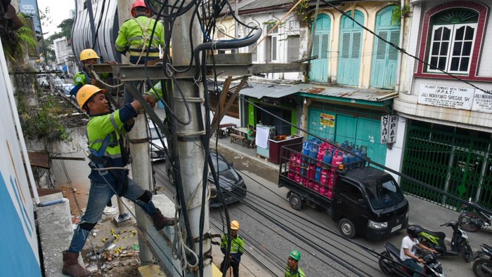 Penampakan Kabel Semrawut yang Hiasi Jalanan di Medan Sejumlah petugas PLN melakukan penataan kabel utilitas di Medan, Sumatera Utara, Sabtu (5/8/2023). Pemko Medan melakukan penataan kabel utilitas di 18 ruas jalan kota Medan sebagai upaya menghadirkan kenyamanan serta keselamatan warga dan ditargetkan selesai pada akhir tahun 2023. ANTARA FOTO/Fransisco Carolio/aww.