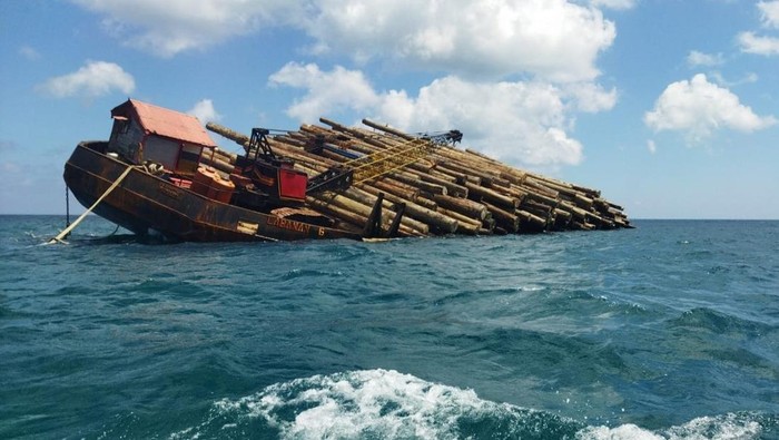 kapal tongkang bermuatan ratusan batang kayu kandas setelah dihantam ombak besar