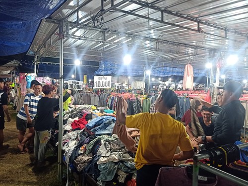 Para pembeli saat memilih baju bekas import di pasar malam yang ada di Lapangan Pergung, Desa Pergung, Kecamatan Mendoyo, Kabupaten Jembrana, Jumat (5/8/2023). (I Putu Adi Budiastrawan/detikBali).