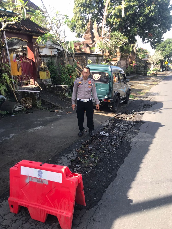Polsek Banjarangkan memasang tanda bahaya atau pengaman di jalan kawasan Desa Nyalian, kecamatan Banjarangkan, Klungkung, Minggu (6/8/2023). (dok Polsek Banjarangkan)