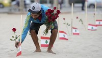 Seorang sukarelawan meletakkan mawar di pantai Copacabana untuk menghormati mereka yang tewas dalam ledakan pelabuhan Beirut di Rio de Janeiro, Brasil, Jumat, 4 Agustus 2023. 