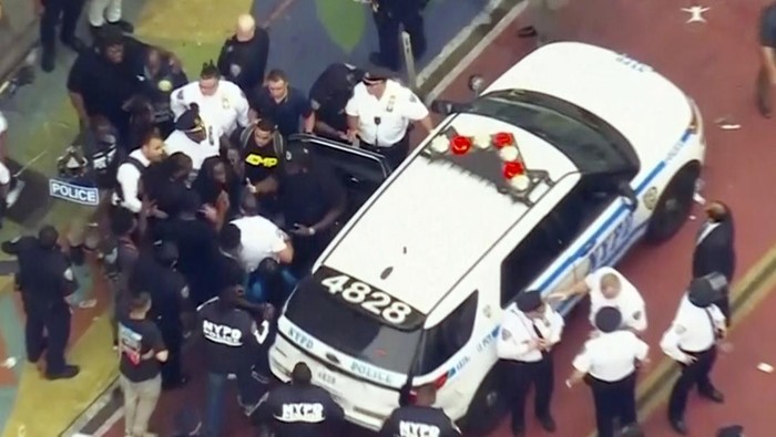 In this image taken from video provided by WABC-TV, internet influencer Kai Cenat, center left, is helped into a New York Police vehicle near Union Square, Friday, Aug. 4, 2023, in New York. Police in New York City struggled to control a crowd of thousands of people who gathered in Manhattans Union Square for the Internet personalitys video game console giveaway that got out of hand. (WABC-TV via AP)