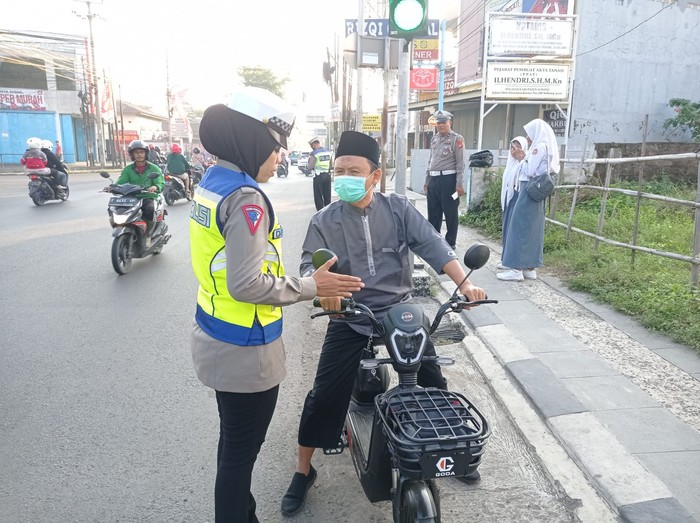 Anggota Satlantas Polres Subang berikan edukasi kepada pengendara sepeda listrik.