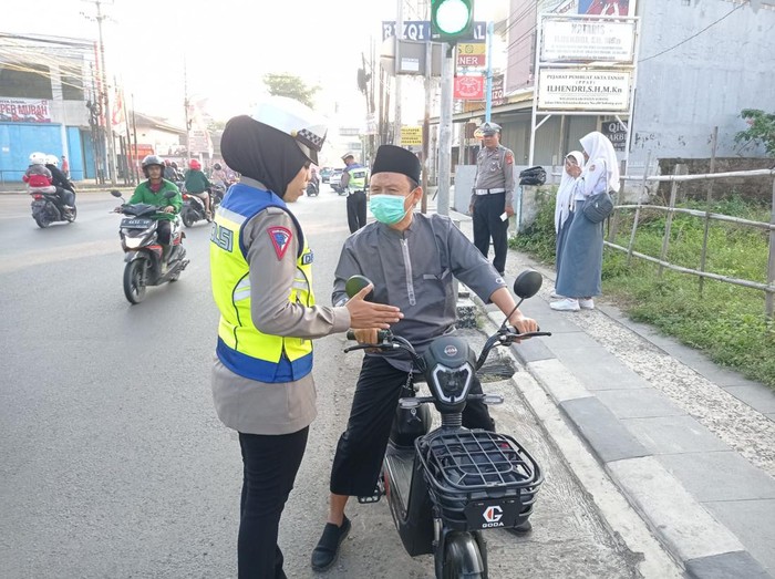 Anggota Satlantas Polres Subang berikan edukasi kepada pengendara sepeda listrik.