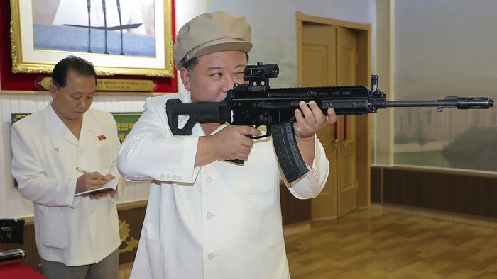 In this undated photo provided by the North Korean government, North Korean leader Kim Jong Un tries a weapon during his three-day inspection from Aug. 3 until Aug. 5, 2023 at major munitions factories in North Korea. Independent journalists were not given access to cover the event depicted in this image distributed by the North Korean government. The content of this image is as provided and cannot be independently verified. Korean language watermark on image as provided by source reads: 